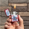 Lifestyle image of Zippo Flag Design Candy Apple Red Windproof Lighter lit in hand.