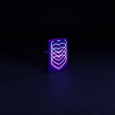 Glamour shot of Zippo Black Light Hearts Design Black Matte Pocklet Lighter glowing with a black light.